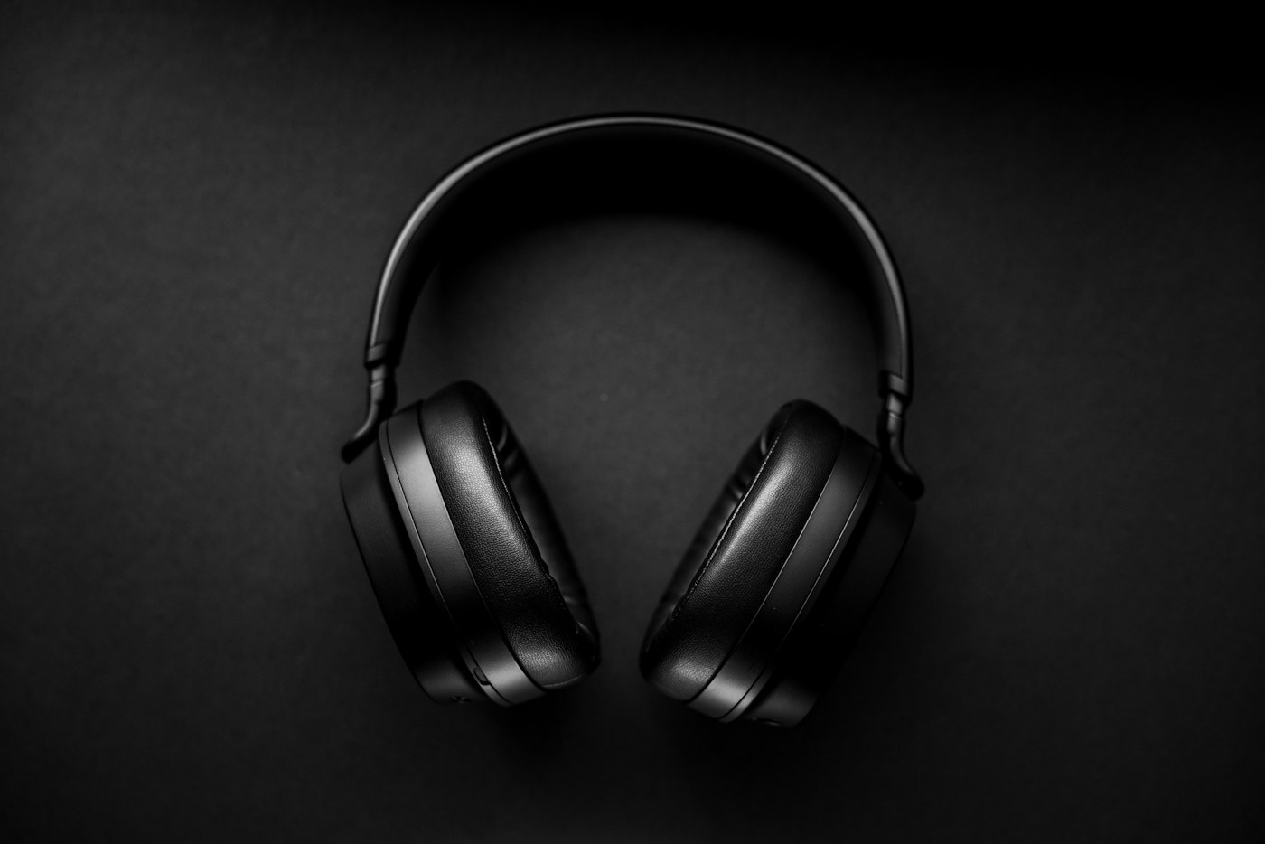 Black wireless headphones on a black surface