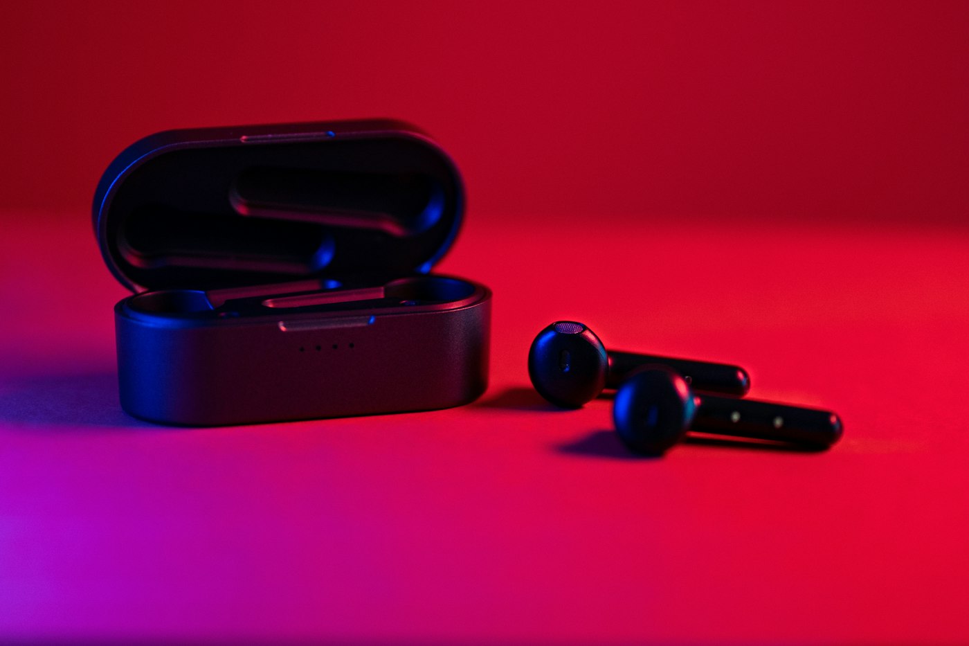 Pulse Buds and their case under coloured light