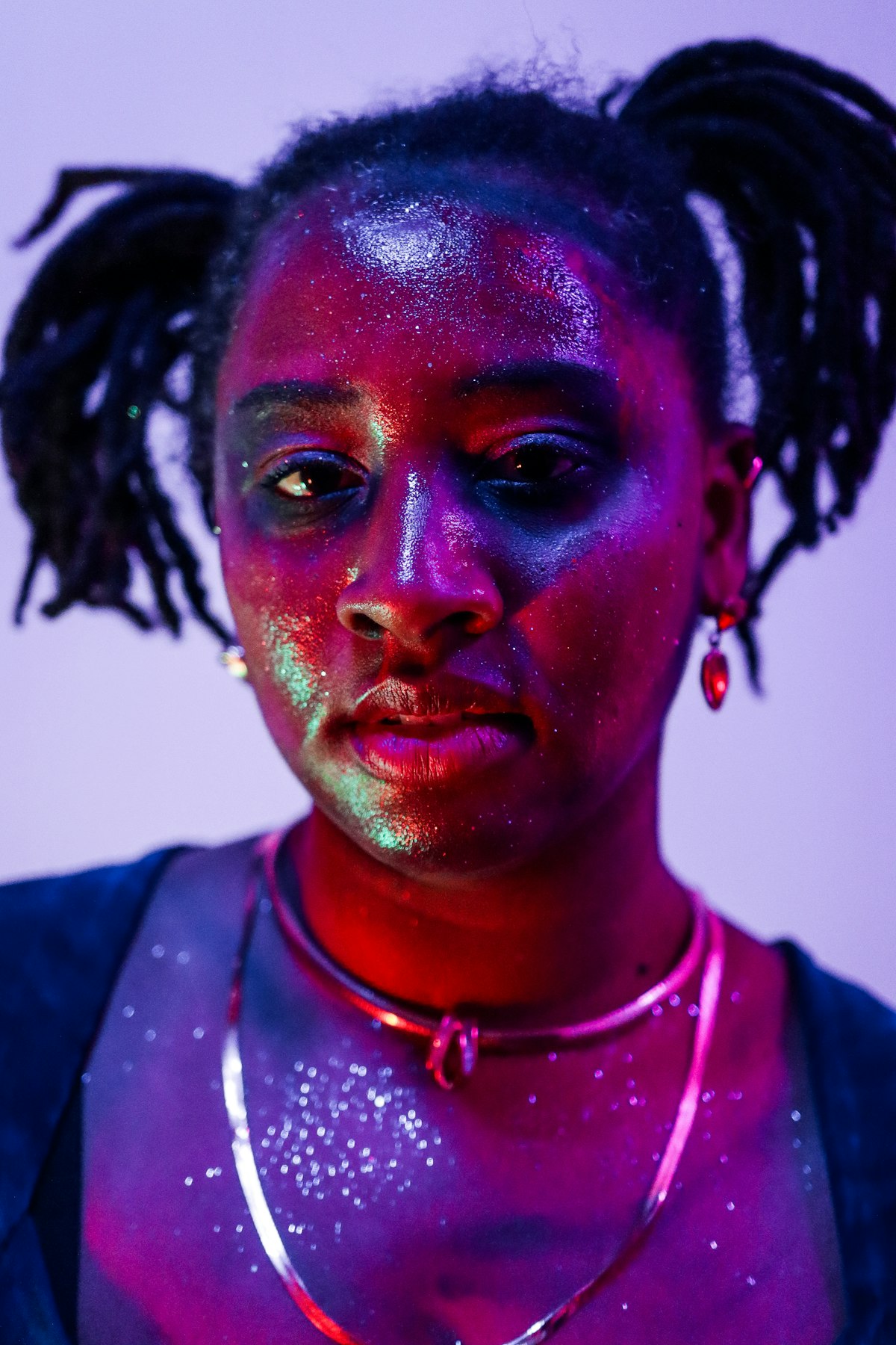 Person with glitter under colourful light